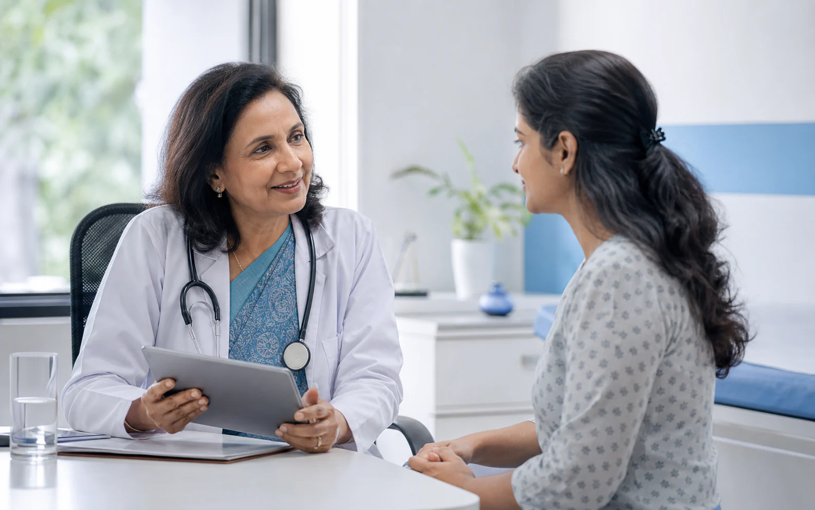 Indian physician listening to a patient during a connected-care consultation
